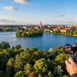 Zdjęcia z drona Olsztyn, operator kontrolujący drona nad jeziorami i zielenią miasta w pięknej scenerii.